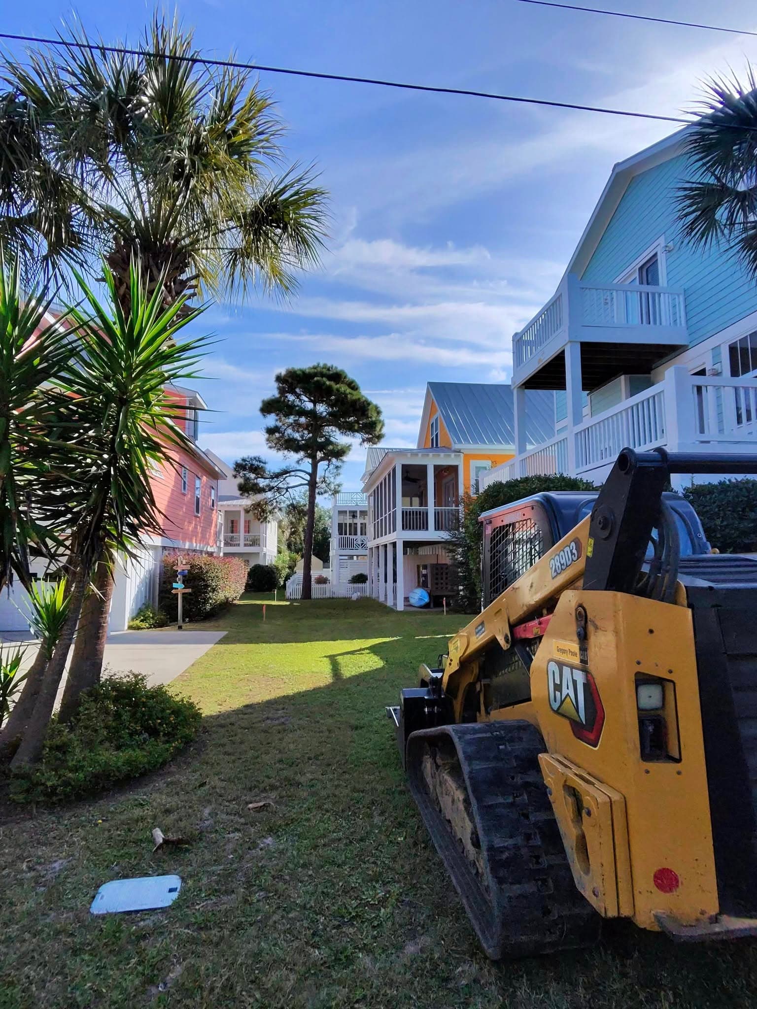 Skid-steer clearing brush on a coastal residential lot